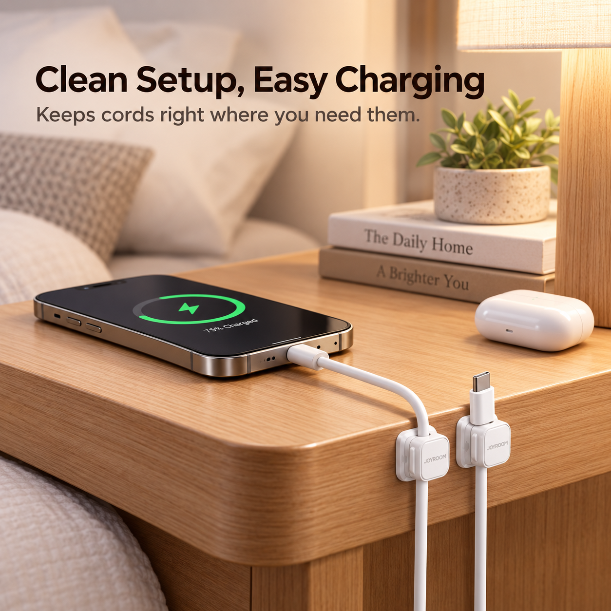 JOYROOM magnetic cable clips holding two charging cords neatly along the edge of a wooden nightstand.